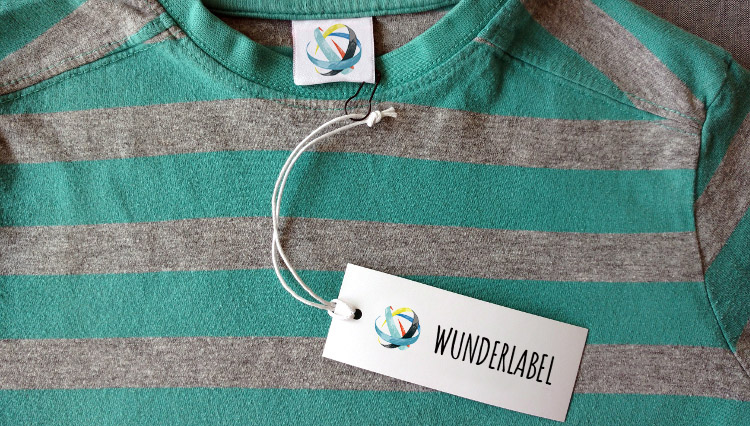 So wird ein Hangtag mit einer Sicherheitsnadel an einem T-Shirt befestigt T-Shirt mit Hangtag: Sicherheitsnadel