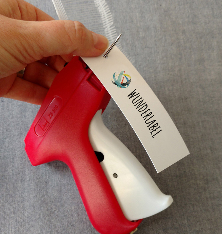 Erster Schritt beim Befestigen eines Hangtags mit einer Etikettierpistole Etikettierpistole mit Hangtag